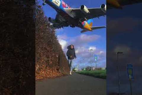 Large plane flies right above woman jogging outside Heathrow Airport