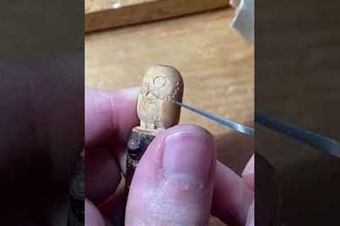 Woman delicately crafts cute owl pendant out of wood